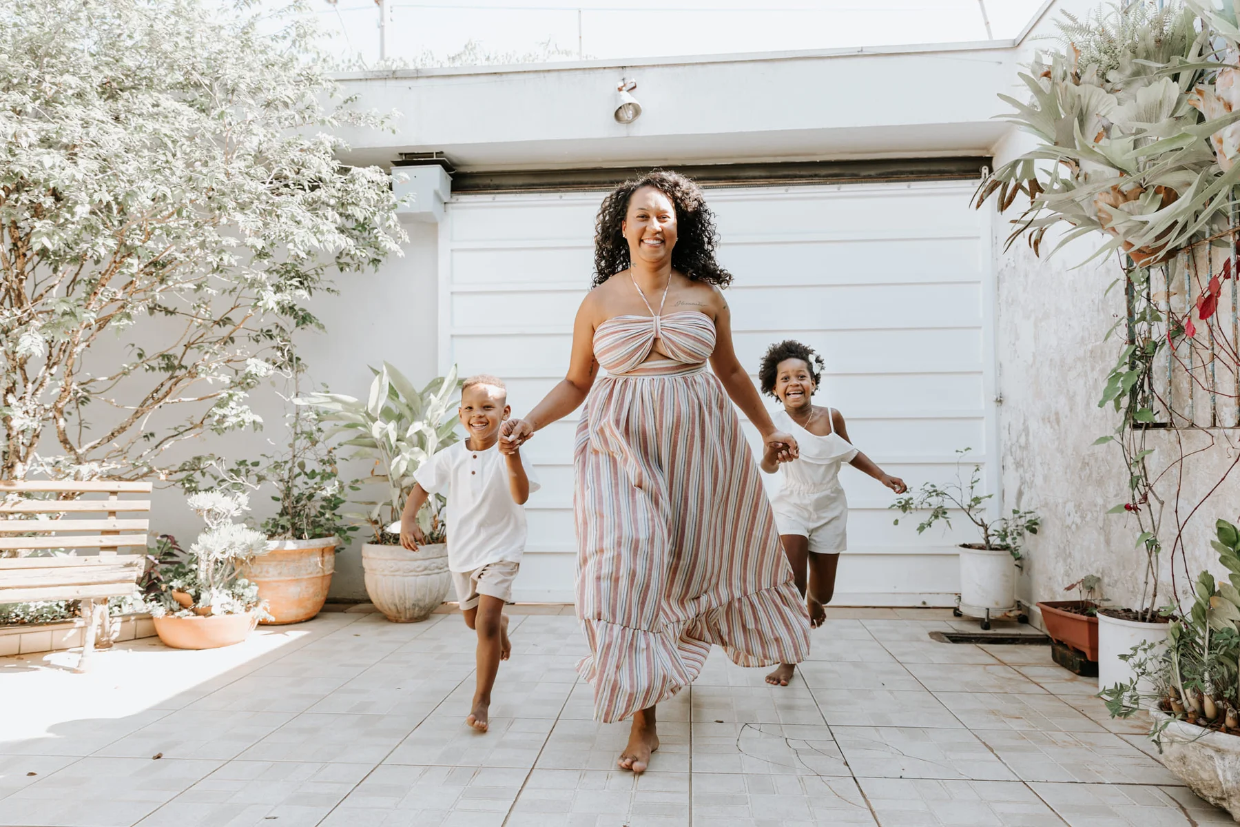 Mother running and laughing with her two children outdoors
