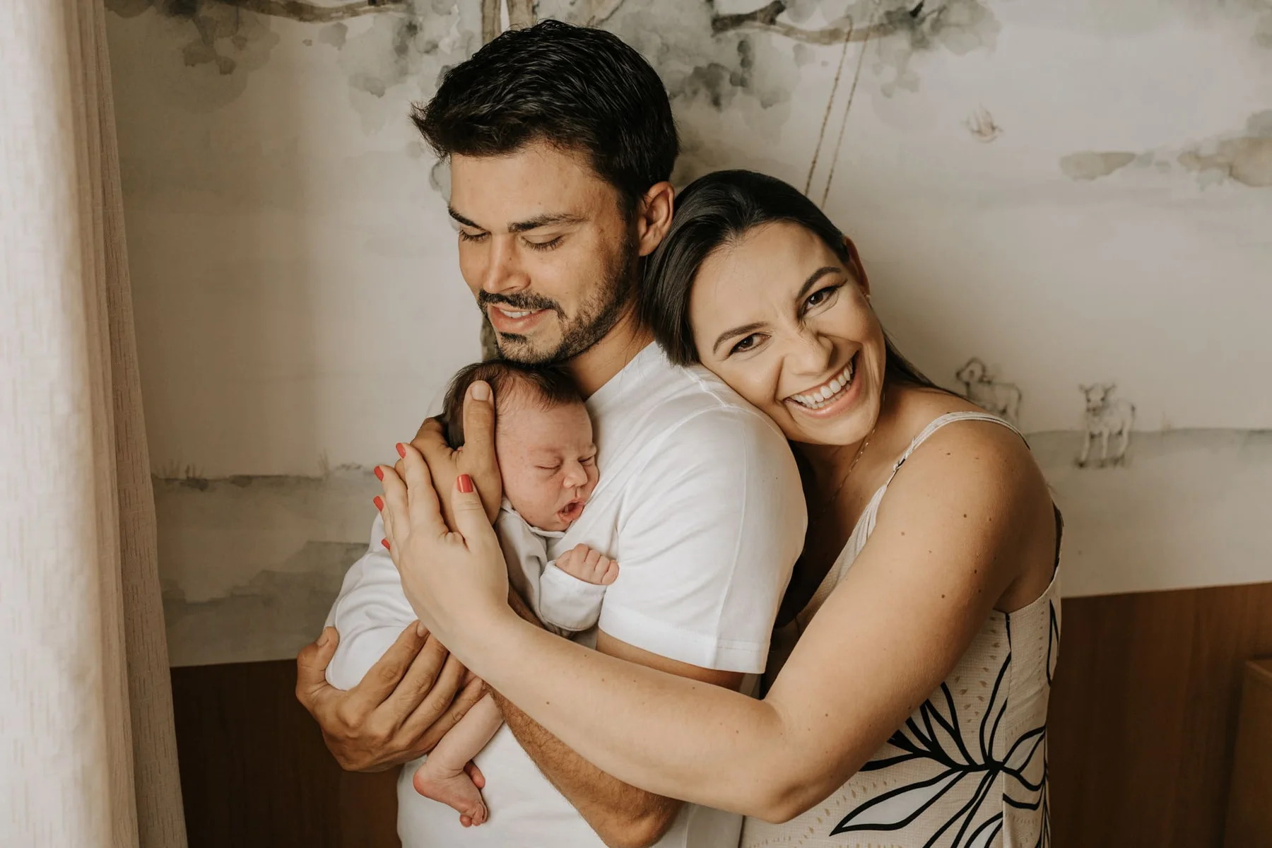 Both parents holding their sleeping newborn close, in home newborn session